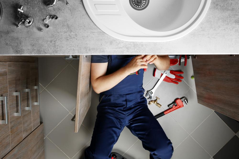 Plombier réparant une canalisation d'évier